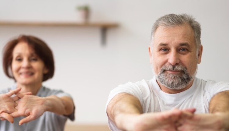 Starsza kobieta i starszy mężczyzna ćwiczą, żeby przeciwdziałać osteoporozie.