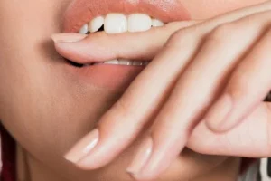 Ekstremalne zblizenie strzal mloda kobieta gryzac palec jpg 300x200