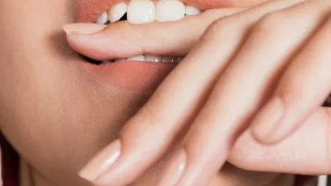 Ekstremalne zblizenie strzal mloda kobieta gryzac palec jpg 470x264