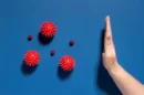 Flat lay hand stopping viruses jpg 130x86