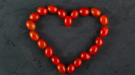 Pomidory czeresniowe czerwone w ksztalcie serca czerwone pomidory na ciemnym biurku scaled 1 470x264