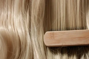 Woman s hand with bright manicure running through long wavy blond hair jpg 300x200