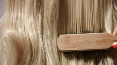 Woman s hand with bright manicure running through long wavy blond hair jpg 470x264