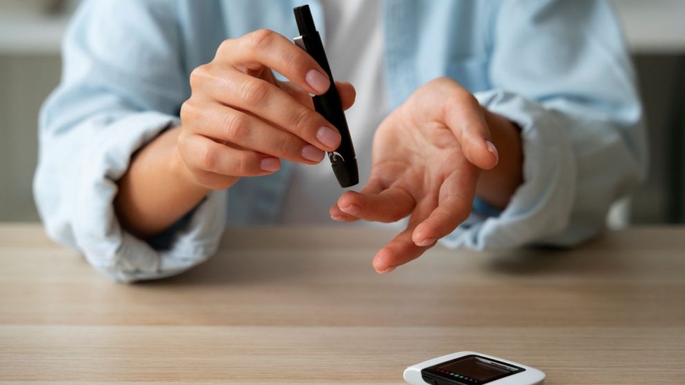 Osoba z cukrzyca sprawdzajaca poziom glukozy 990x556