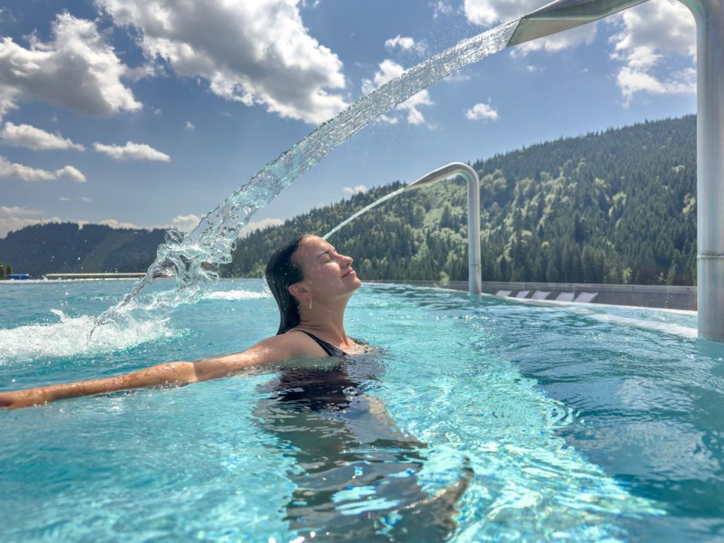 Woman infinity pool water arc mountain wellness 1 1024x768