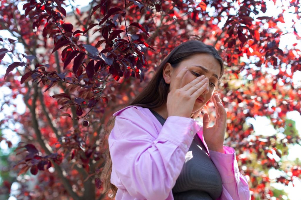 Woman suffering from allergies outside 1024x682