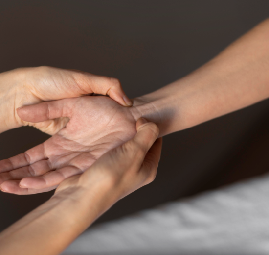 Close up hands massaging wrist 550x520