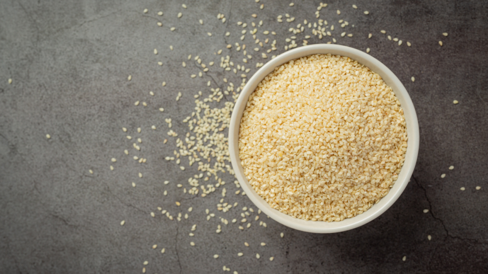 Sesame seeds bowl dark background 990x556