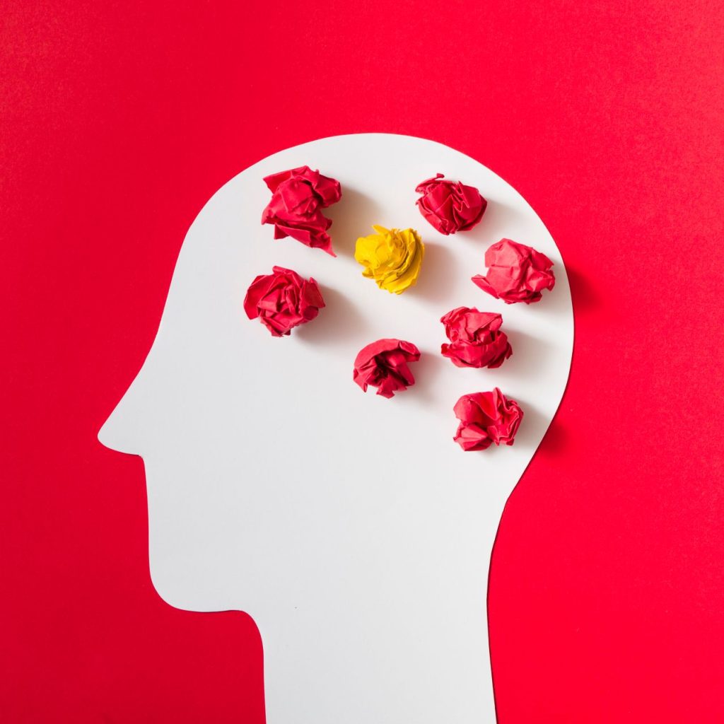 Crumpled paper cut out white human head red background 1024x1024