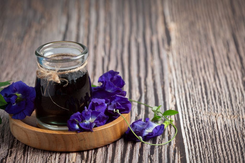 Glass butterfly pea flower tea put wooden tray 1024x682