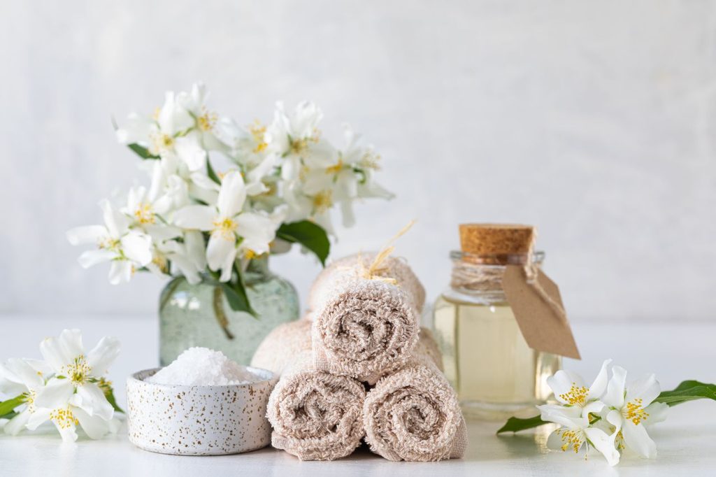 Spa concept jasmine oil with bath salt flowers 1024x682