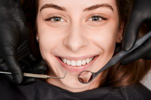 Cheerful young woman having dental examination clinic 300x200