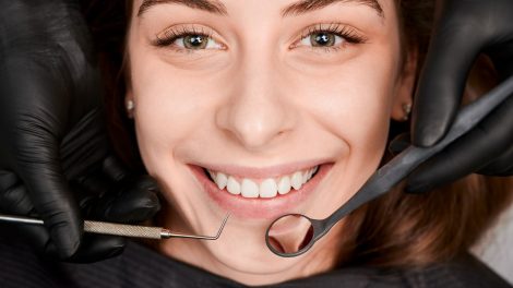 Cheerful young woman having dental examination clinic 470x264